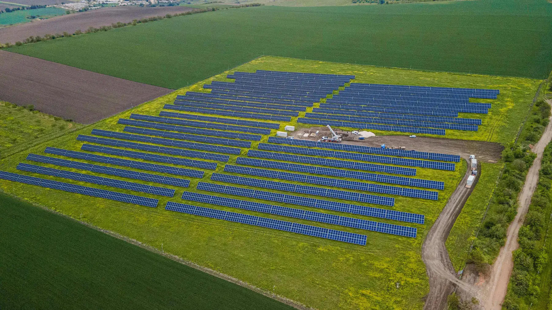 Aerial view of a utility-scale solar development surrounded by farmland